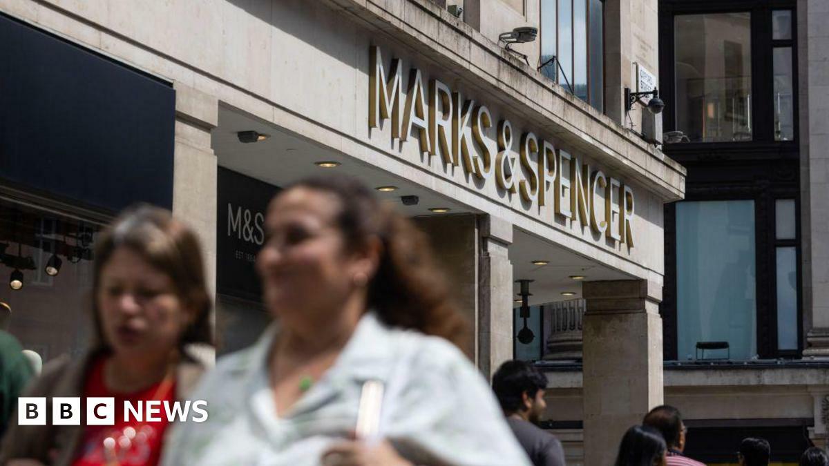 A Marks & Spencer shop on a busy high street in summer