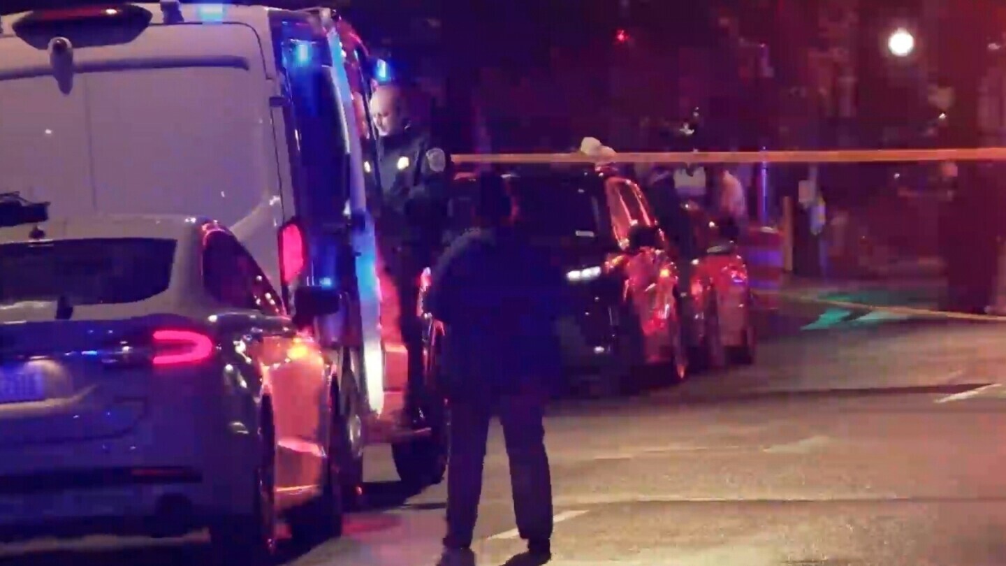 In this image taken from video provided by WJLA, a bystander watches as law enforcement works the scene after two staff members of the Israeli embassy in Washington were shot and killed outside the Capital Jewish Museum on Wednesday, May 21, 2025, in Washington. (WJLA via AP)