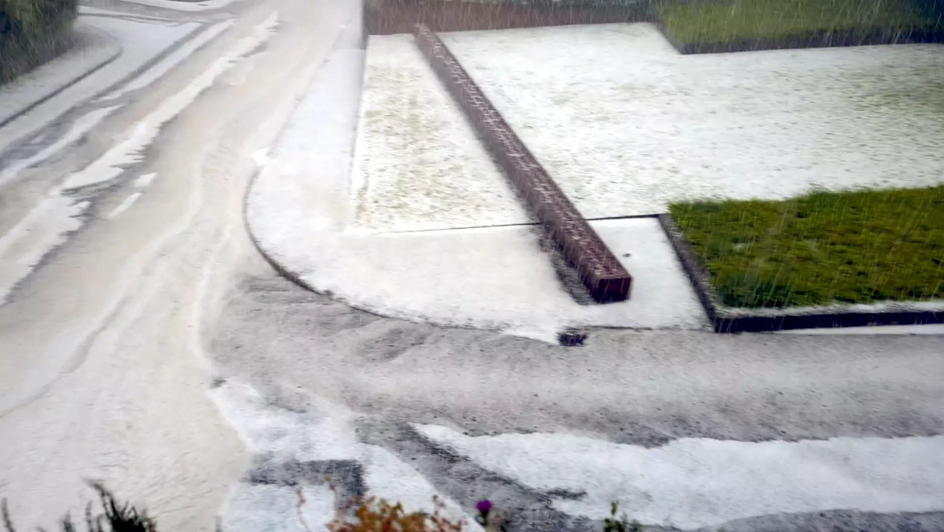 in der Mitte das Synagogendenkmal die Straßen davor und links sind zu Sturzbächen mit Hagel und Regen geworden