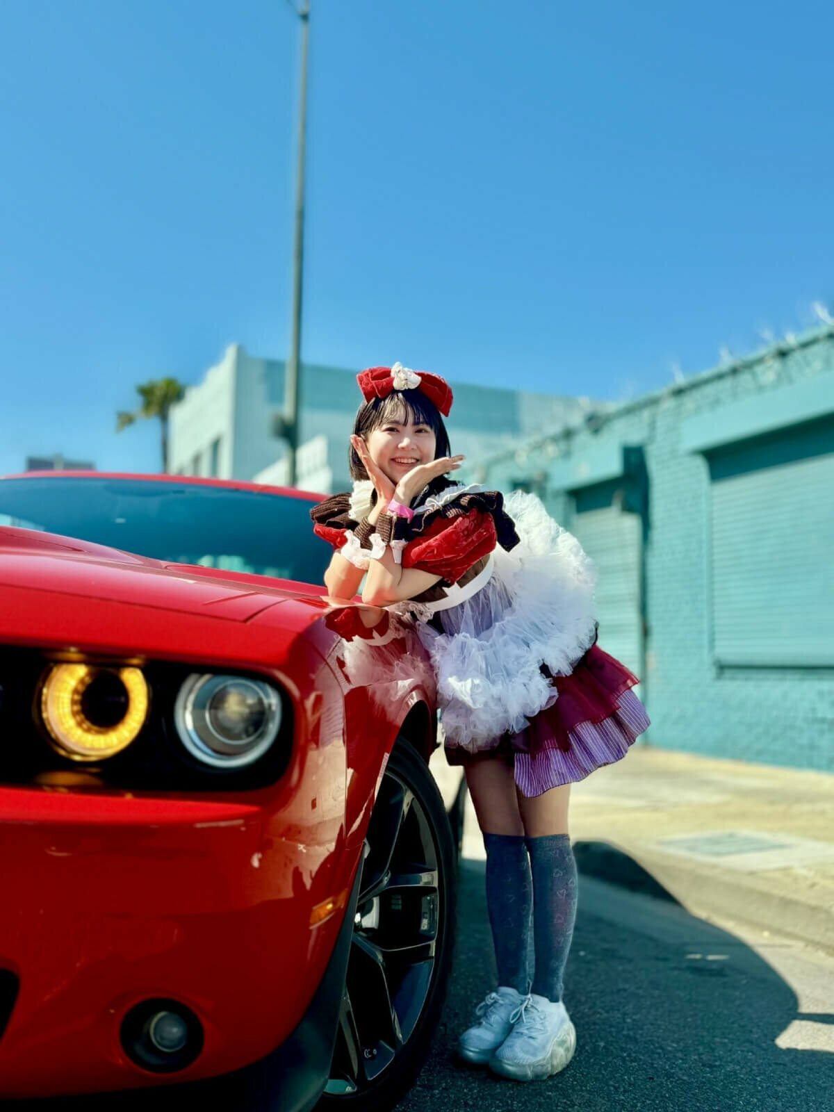 The photo features YURAPICO posing next to a red car in Los Angeles.
