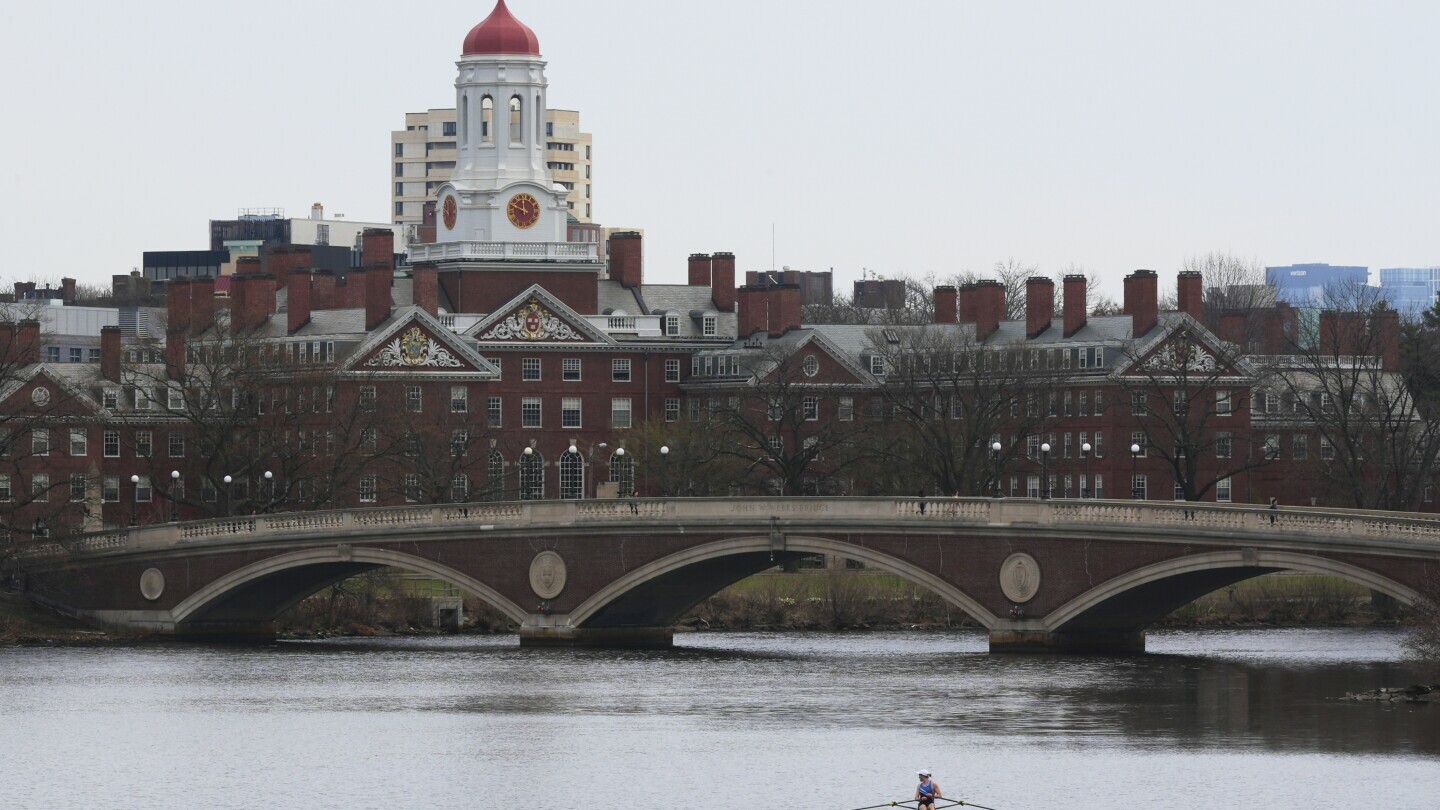A sculler rows down the Charles River near Harvard University, at rear, Tuesday, April 15, 2025, in Cambridge, Mass. (AP Photo/Charles Krupa, File)