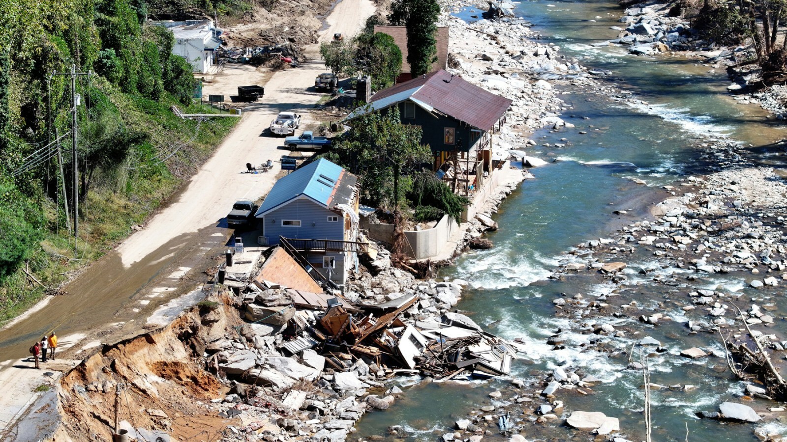BAT CAVE, NORTH CAROLINA - OCTOBER 08: An aerial view of people standing near destroyed and damaged buildings in the aftermath of Hurricane Helene flooding on October 8, 2024 in Bat Cave, North Carolina. Bat Cave was particularly hard hit by flooding. Recovery efforts continue as the death toll has risen to over 230 while the powerful Hurricane Milton is on track to make landfall in Florida. (Photo by Mario Tama/Getty Images)