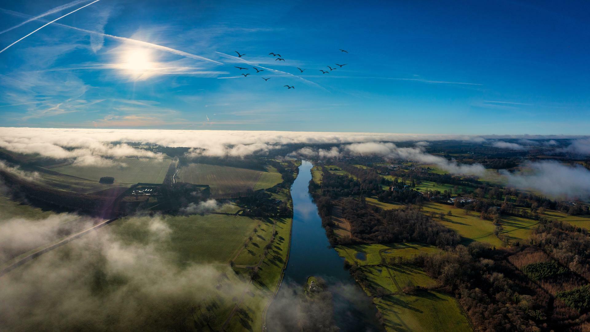 Ein Luftbild der Stadt Henley-on-Thames umgeben von grünen Feldern und Wasser.