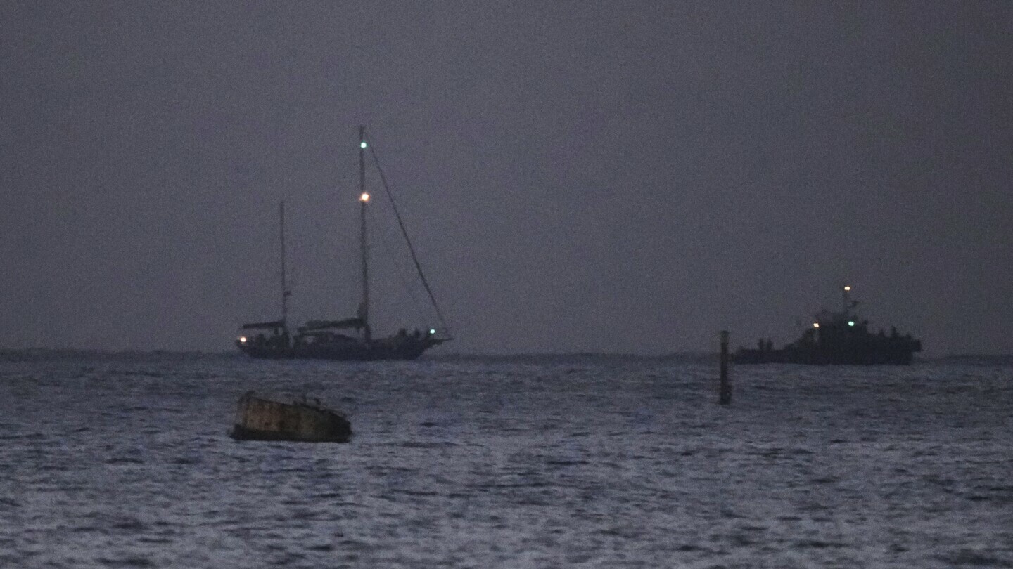 The Gaza-bound aid boat, Madleen, left, under escort of Israeli naval forces making its way toward Ashdod Port in southern Israel after being seized by Israeli forces, Monday, June 9, 2025. (AP Photo/Leo Correa)