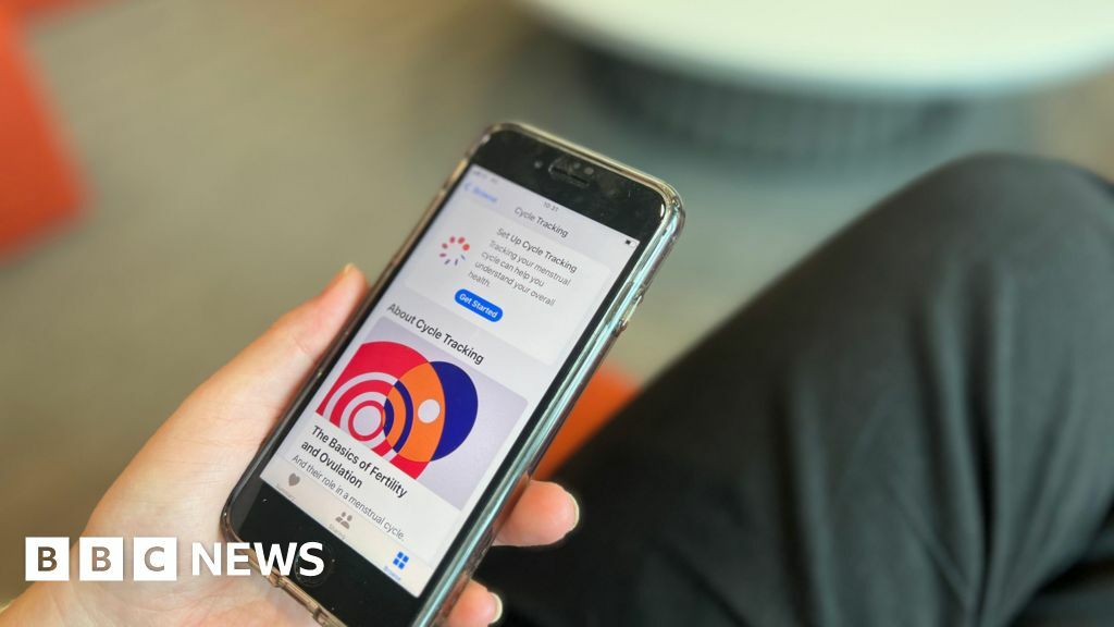 A person on their phone looking at a health app which says 'about cycle tracking'.