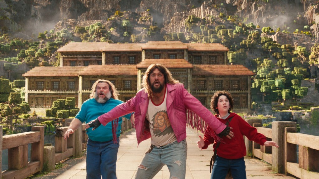 Jack Black, Jason Momoa and Sebastian Hansen take a wide stance on a bridge in 'A Minecraft Movie'.
