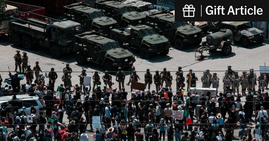 A large crowd gathered in front of a line of National Guard troops at the Metropolitan Detention Center in Los Angeles on Sunday. 