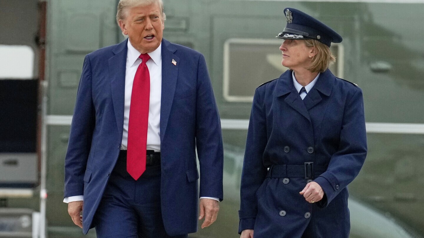 President Donald Trump, left, escorted by Air Force Col. Angela F. Ochoa, Commander, 89th Airlift Wing, walks from Marine One to board Air Force One, Sunday, June 15, 2025, at Joint Base Andrews, Md., for a trip to Canada to attend the G7 Summit. (AP Photo/Mark Schiefelbein)