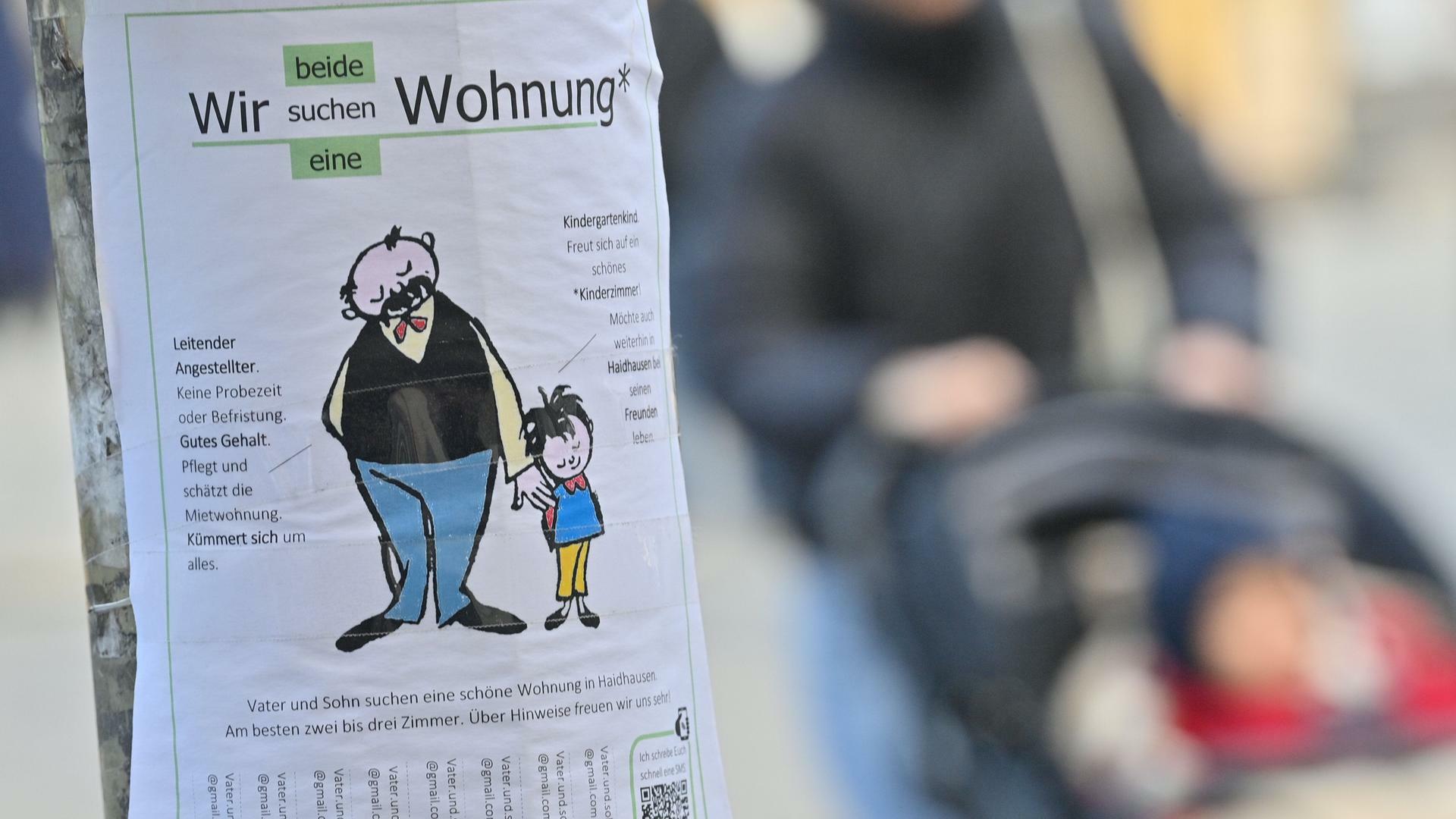 Mit einem Zettel mit der Aufschrift "Wir beide suchen eine Wohnung" an einem Laternenpfahl im Stadtteil München-Haidhausen sucht ein Vater mit seinem Sohn eine Wohnung.