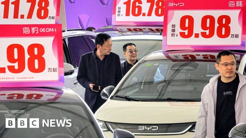 Customers look at BYD electric cars at an auto show in Yantai, in eastern China's Shandong province on April 10, 2025.