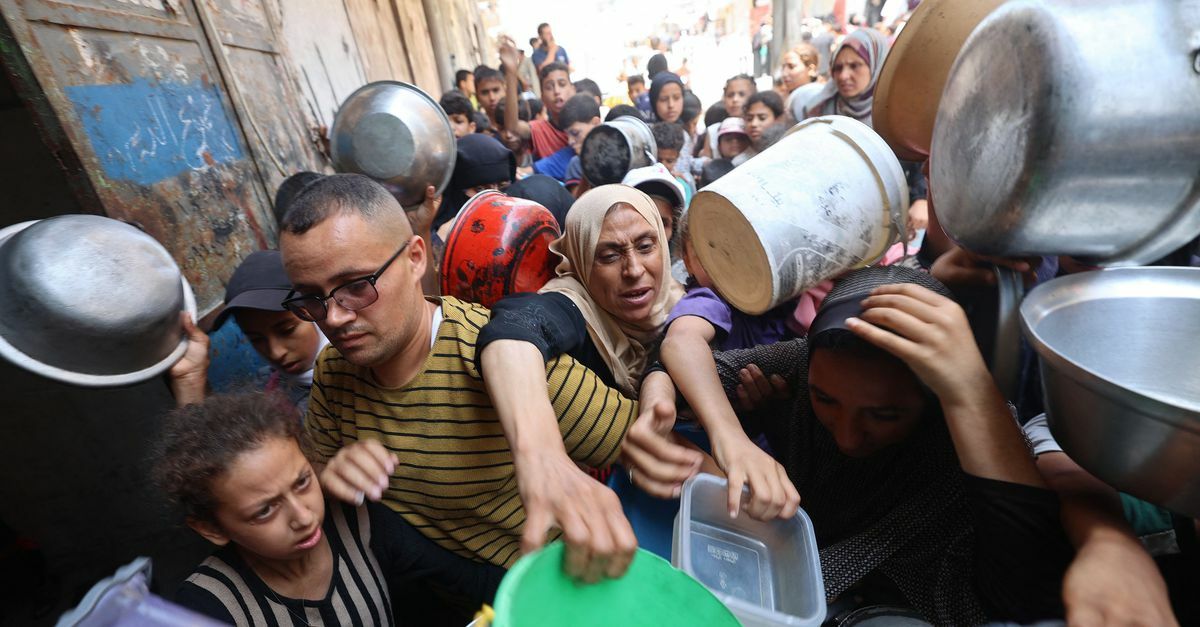 Palestijnen maandag bij een voedseldistributiepunt in Nuseirat, in de Gazastrook. Foto Eyad Baba/AFP  