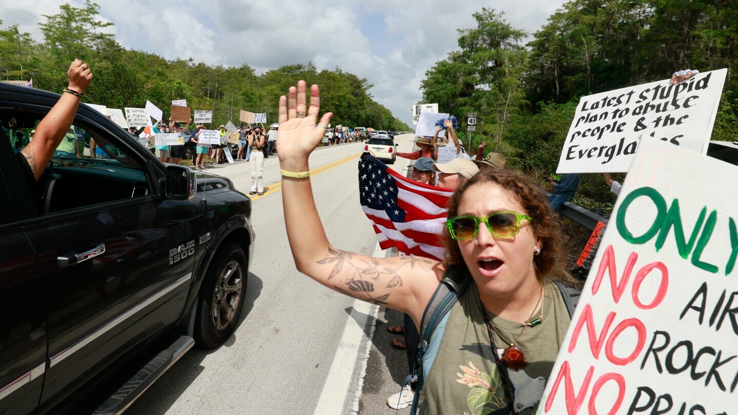 Environmental advocates and protesters at the Dade-Collier Training and Transition Airport on Tamiami Trail E, Ochopee, Fla., on Saturday, June 28, 2025, object to the "Alligator Alcatraz" being built at the facility. (Mike Stocker /South Florida Sun-Sentinel via AP)
