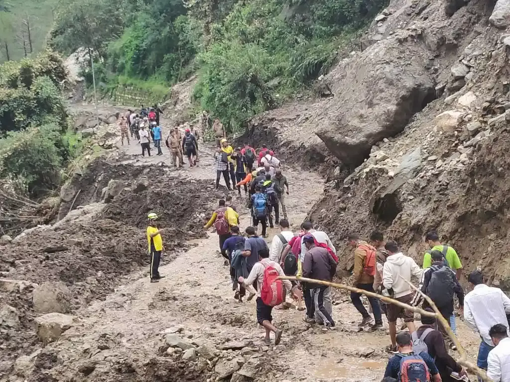 Pedestrians going through the damaged Yamunotri National Highway.