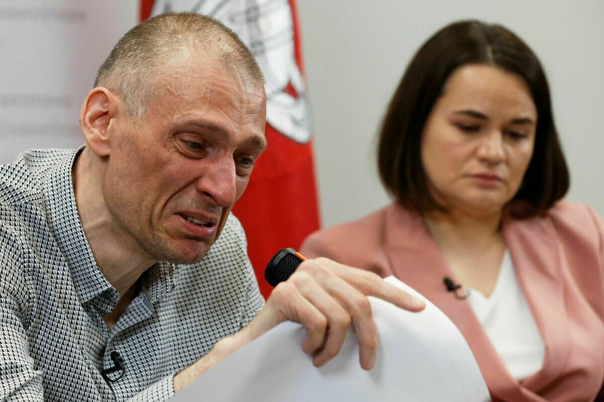 Ein Mann und eine Frau sitzen nebeneinander. Der Mann spricht unter Tränen mit Vertretern der Presse Ein Mann und eine Frau sitzen nebeneinander. Der Mann spricht unter Tränen mit Vertretern der Presse