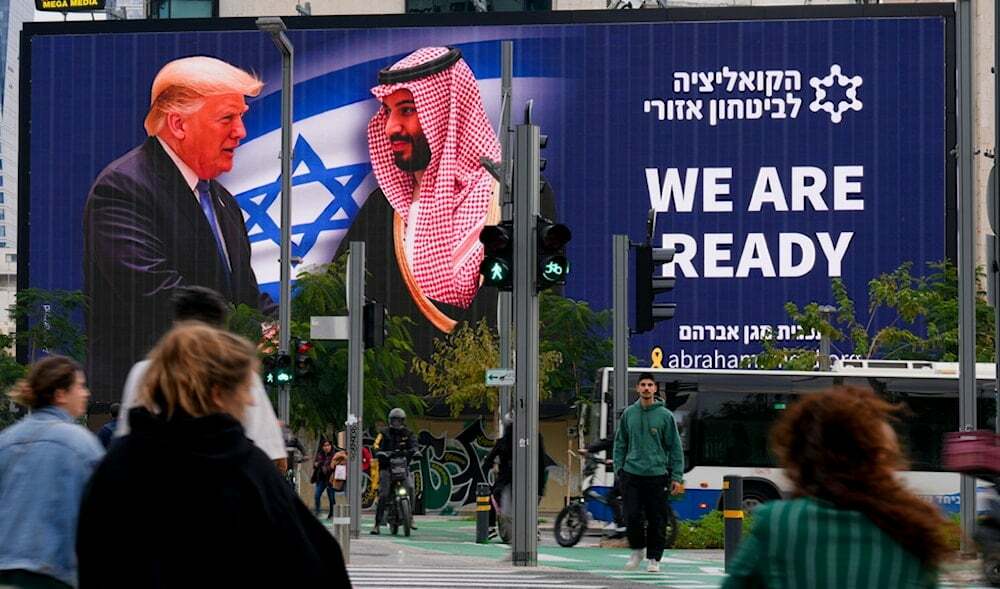 People walk past an electronic billboard shows U.S. President Donald Trump, left, shaking hands with Saudi Crown Prince Mohammed bin Salman with text that says: "We are ready," in Tel Aviv, Monday, Feb. 3, 2025. (AP)