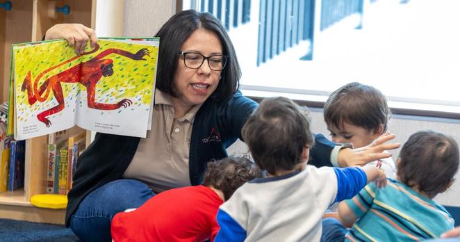 Long Beach, CA - March 20: Teacher Monica Alvarado, left, reads to the youngest students in the infant class at Educare Los Angeles at Long Beach, a very high-quality child care center in Long Beach on Wednesday, March 20, 2024 in Long Beach, CA. (Brian van der Brug / Los Angeles Times)