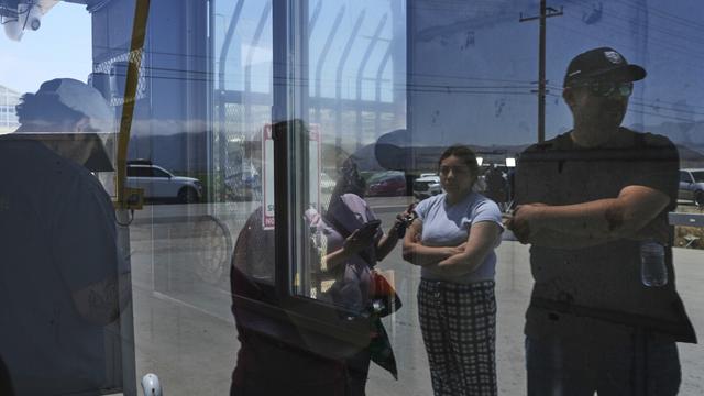 People wait outside of Glass House Farms, a day after an immigration raid on the facility, Friday, July 11, 2025, in Camarillo, Calif. (AP Photo/Jae C. Hong)