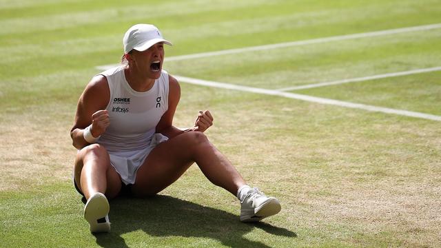 Assise sur le court, elle crie de joie.