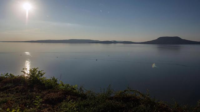 Das Bild blickt von der südlichen Seite auf den Plattensee. Der Himmel ist blau, anhand des Sonnenstandes kann man vom späten Nachmittag im Sommer ausgehen. Das Bild blickt von der südlichen Seite auf den Plattensee. Der Himmel ist blau, anhand des Sonnenstandes kann man vom späten Nachmittag im Sommer ausgehen.
