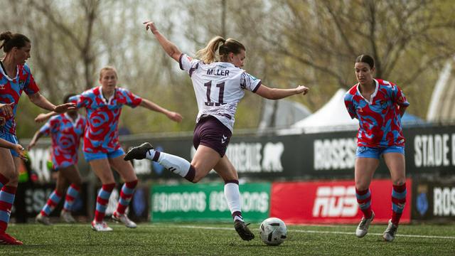 Une joueuse de soccer s'apprête à frapper le ballon du pied droit.
