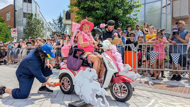 Une femme sourit pendant que le mécanicien prépare son bolide.