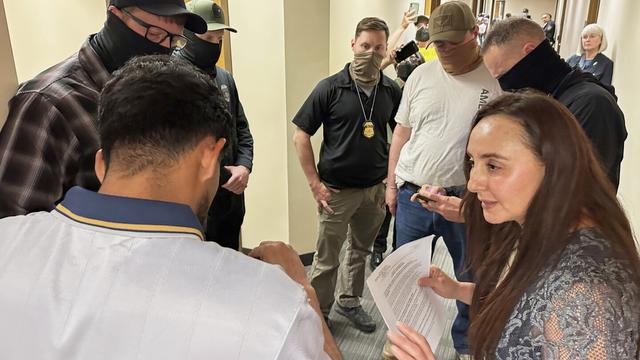 Immigration court volunteer Marjorie Miller gives guidance and support to a Colombian man who was about to be taken into custody by Immigration and Custom Enforcement officers in the hallway after his hearing with an immigration judge in Seattle, June 3, 2025. (AP Photo/Martha Bellisle)