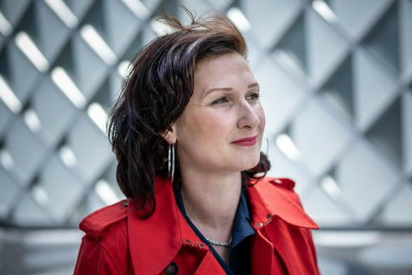 Porträt von Ferda Ataman - sie trägt eine rote Jacke und roten Lippenstift