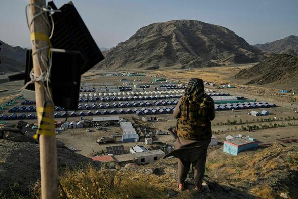 Ein Taliban-Kämpfer bewacht ein Lager von afghanischen Flüchtlingen, die Pakistan in den letzten Monaten verlassen mussten Ein Taliban-Kämpfer bewacht ein Lager von afghanischen Flüchtlingen, die Pakistan in den letzten Monaten verlassen mussten