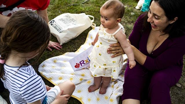 Caroline Doennez smiles as she holds up her nine-month-old daughter, Violet, during the Flint Rx Kids Baby Parade event on July 25, 2025 in on Applewood Campus in Flint, Michigan. The event celebrates the continued impact of Rx Kids on Flint families and babies. (AP Photo/Emily Elconin)