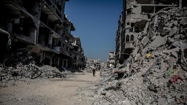 Das Foto zeigt ein Schneise inmitten von Ruinen durch die ein Mensch läuft in der durch den Krieg zerstörten Stadt Jabalia im Gazastreifen am 25. Oktober 2025.