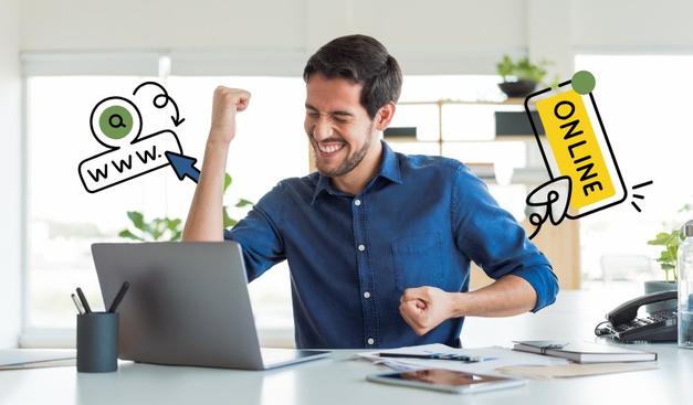 A person in a blue shirt sits at a desk with a laptop, raising their fists in celebration.
