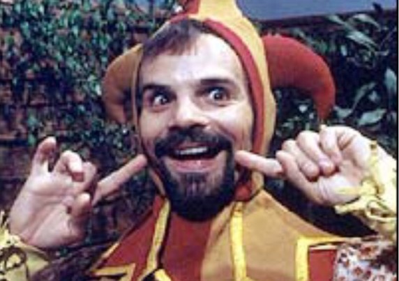 Actor Michael Staniforth, with a beard, in a jester's costume as Mr Claypole in Rentaghost.