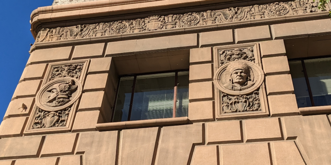 Stone reliefs of a Native American and a Roman soldier on a building in downtown LA