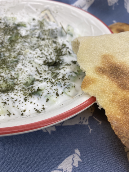 Closeup of salad and broken half of pita bread 