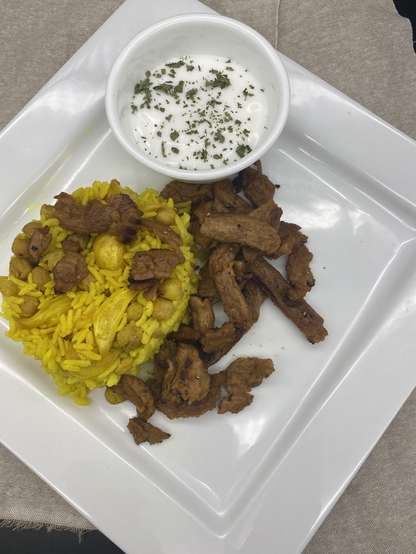 Rice and soy curls on a plain white square plate  small bowl with yogurt 