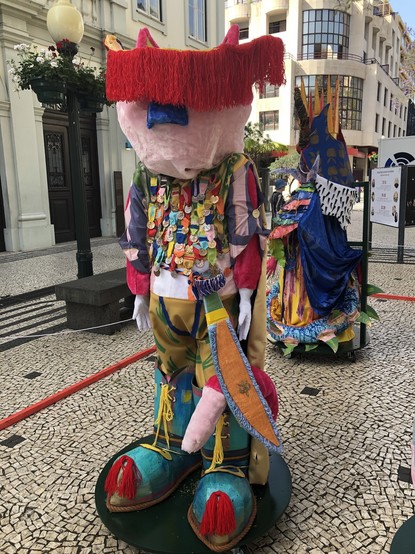 Colourful figures around life size with clown shoes. Could be imaginary characters from books. Look like full size puppets.