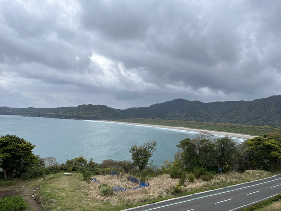 View across a bay ringed by mountains as storm clouds gather in the sky