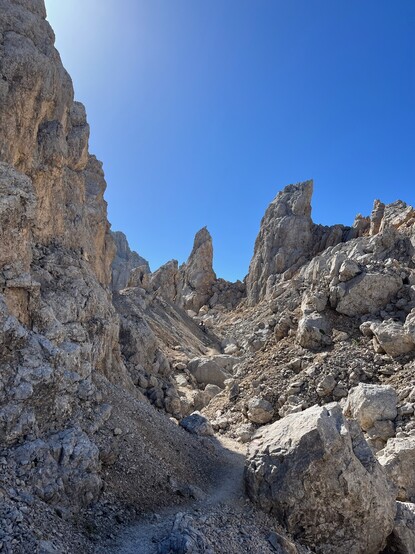 Another view on one of those enclosed rock valleys in the Latemar. A 'white-red' hiking path marker can be seen on the rock in front.
When looking carefully, and zooming in, a small hiker can be seen in the middle of the image, giving a feeling of the scale.