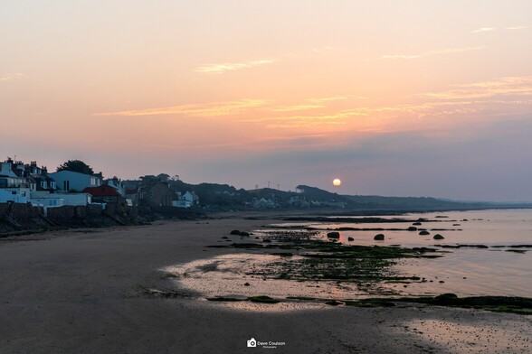 Sunrise on Lower Largo beach with a clear outline of the sun as it struggles to burn through low cloud cover.
