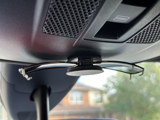 Sunglasses clip-ons in a pop socket installed in a car