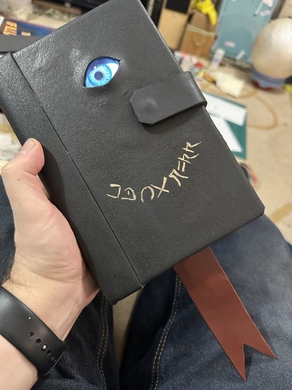 A prop grimoire “The Darkness”, with electronic eye and tongue bookmark. 