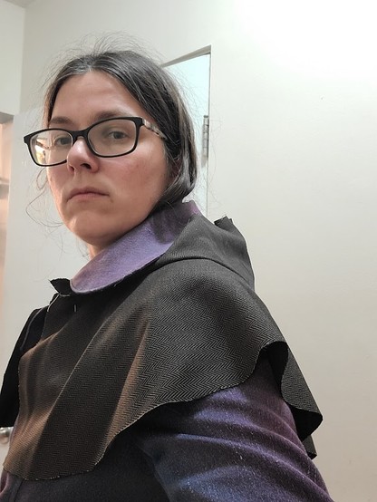 The hood pushed back and the cape visible from the side.