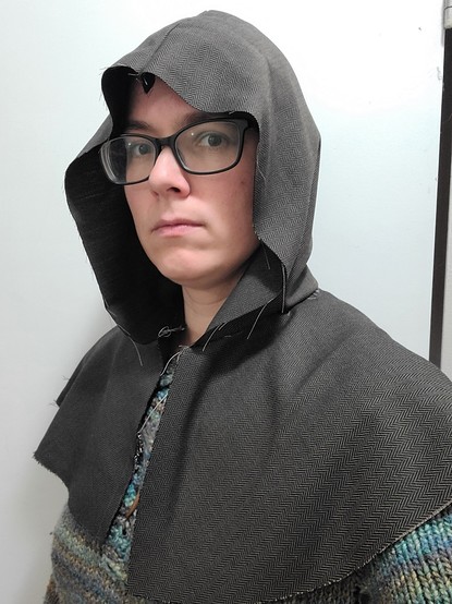 A woman wearing a hood that no longer flops over her eyes.