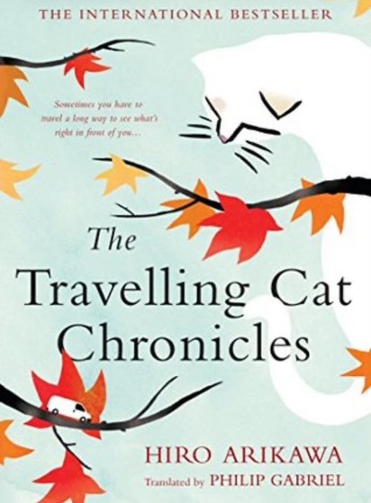 Cover of the book "The Travelling Cat Chronicles" by Hiro Arikawa, translated by Philip Gabriel, featuring a stylized illustration of a cat's face and autumn leaves on branches.