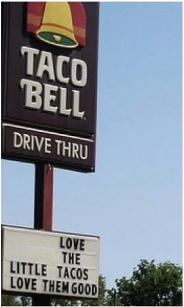 A photo of a retro Taco Bell sign that reads TACO BELL DRIVE THRU against the blue sky. The modifiable marquee sign under it reads LOVE THE LITTLE TACOS LOVE THEM GOOD