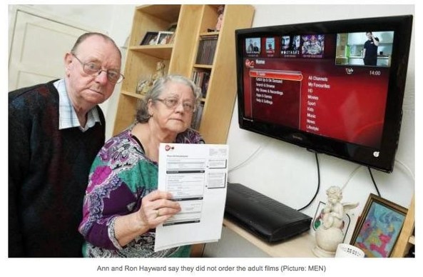 An elderly couple with sad expression pose with a tv and a bill. The caption reads: Ann and Ron Hayward say they did not order the adult films. 