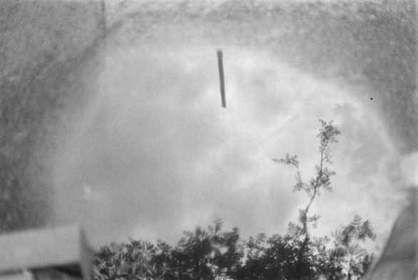 A black and white image of reflections in a puddle.