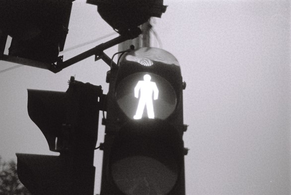 A black and white image of a traffic light against the sky