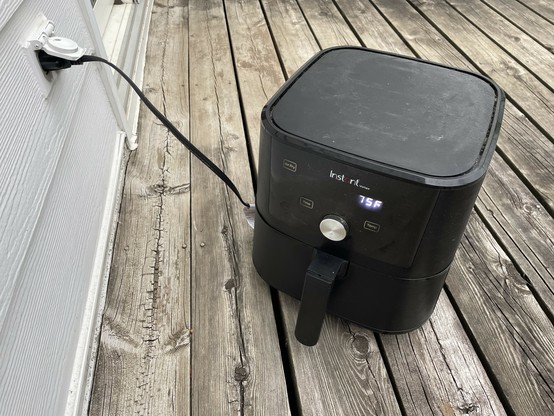 A picture of my air fryer on my deck plugged into the outdoor electric socket.