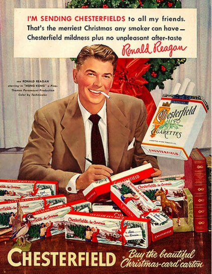 1948 magazine ad. Ronald Reagan, cigarette in mouth, signing cartons of cigarettes done up in Christmas colors. The text reads “I’M SENDING CHESTERFIELDS to all my friends. That’s the merriest Christmas any smoker can have – Chesterfield mildness leaves no unpleasant aftertaste.” followed by his signature.